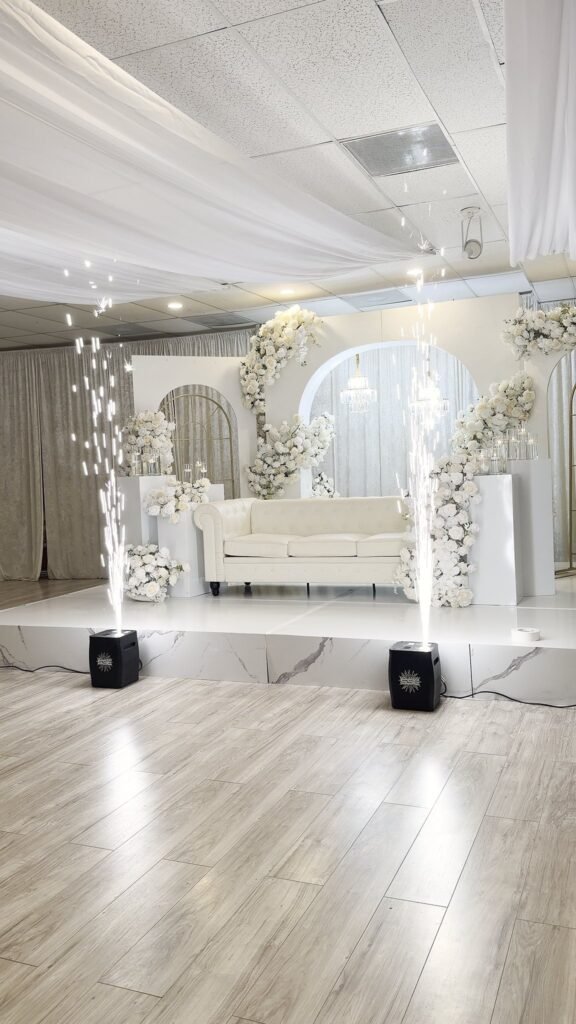 White lounge seating framed by a floral arch at 5959 West event venue, Orlando
